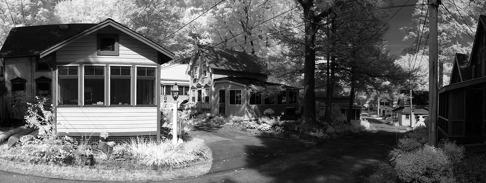 Infrared Panorama of Small Rustic Houses and Streets in a Forest.